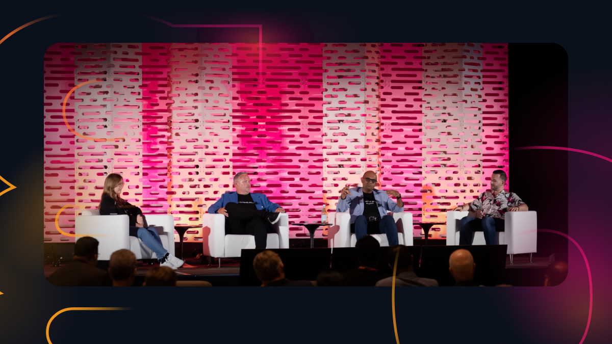 Four speakers engaging in a discussion onstage.